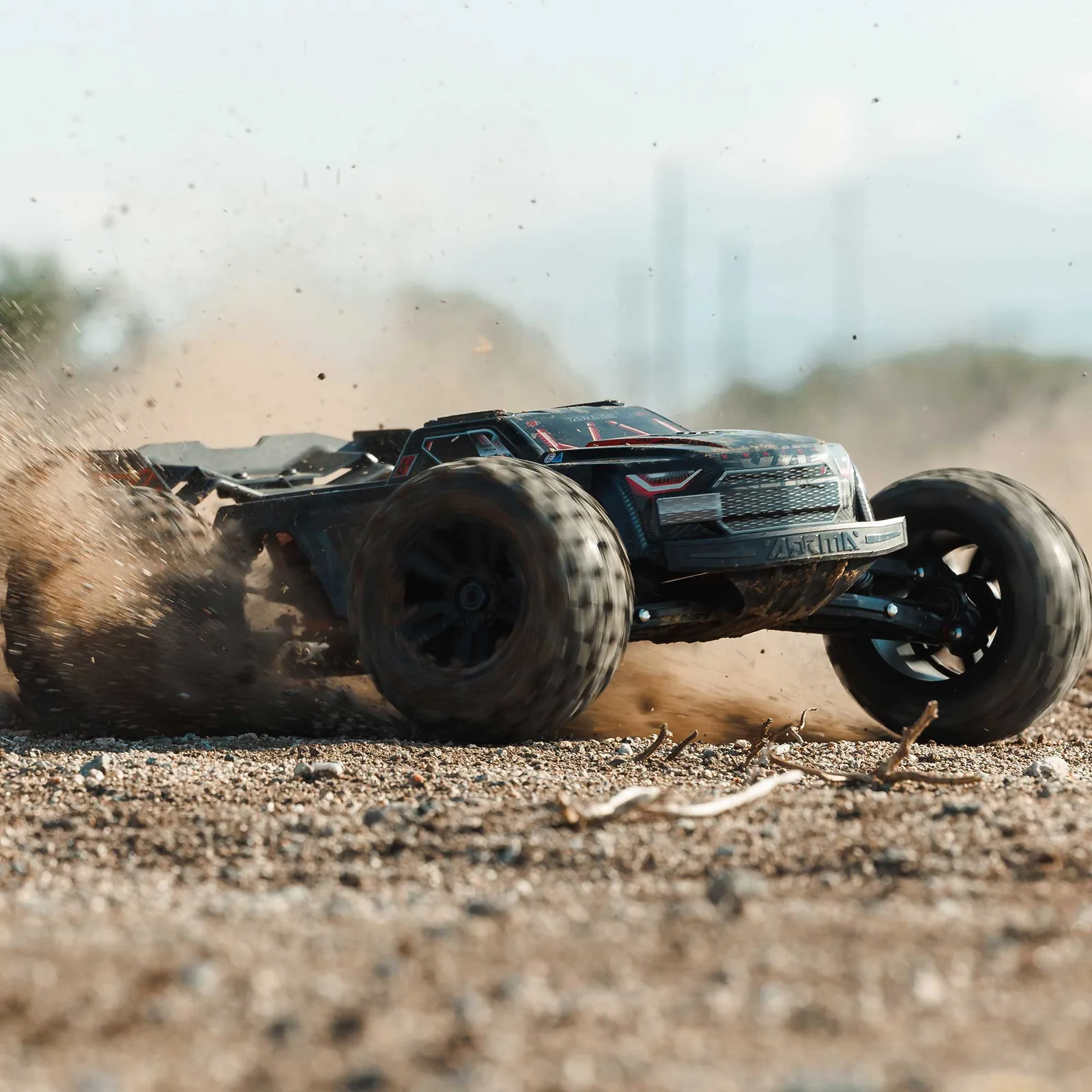 ARRMA Kraton 6S EXB שחורה מעיפה ענן אבק ואבנים בשטח